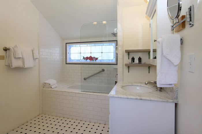 carmel lodging bathroom with tub, sink and tile floor