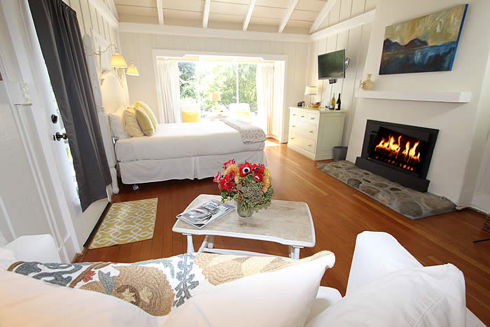 ocean avenue room with bed, fireplace, couch