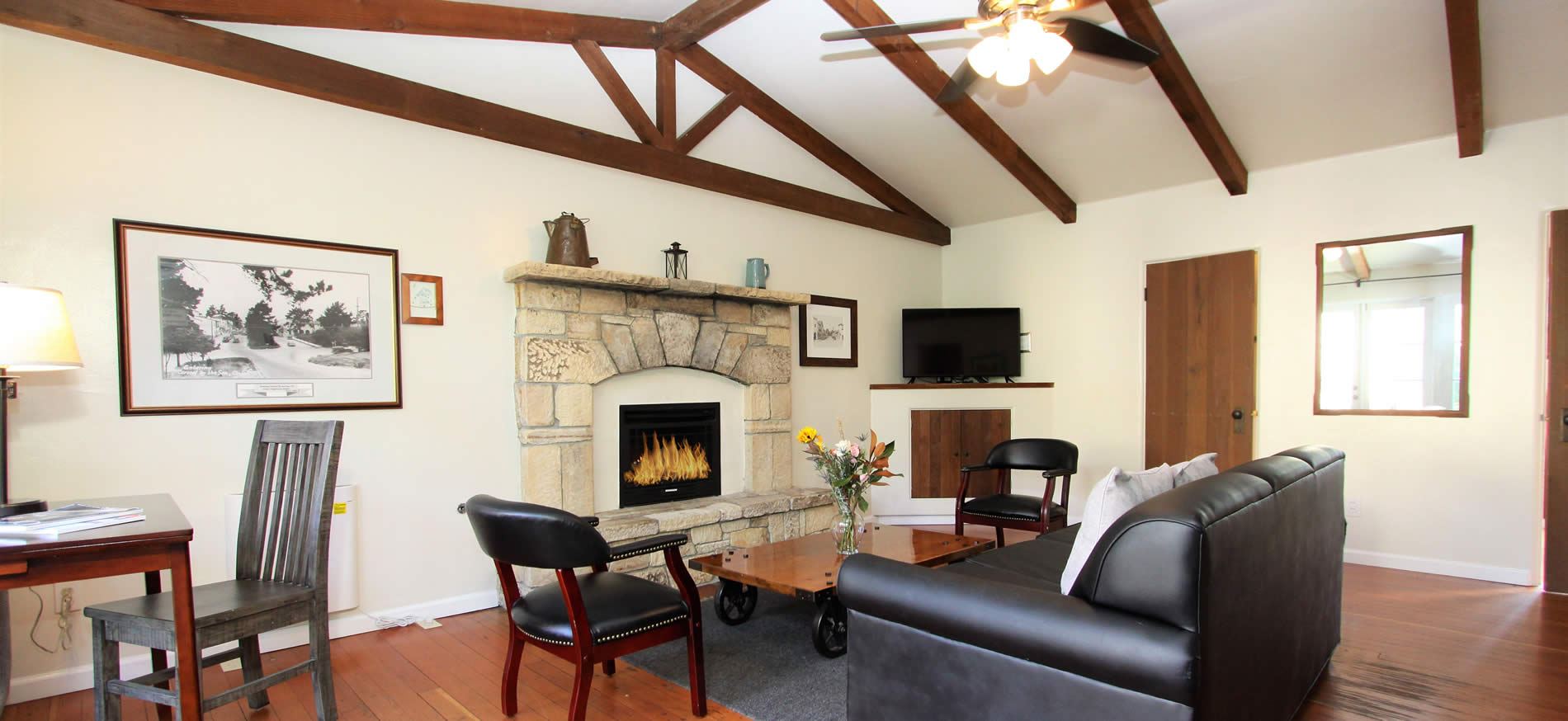 carmel vacation cottage living room with couch stone fireplace and chairs