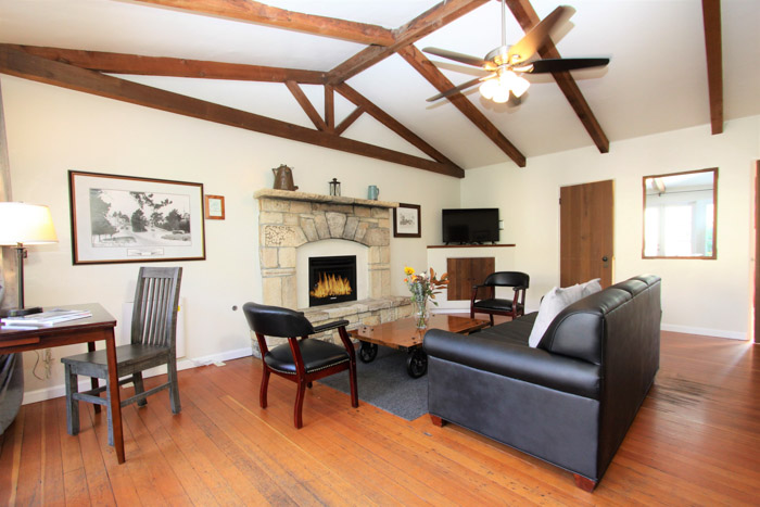 carmel lodging living room with fireplace, couch, desk and chair