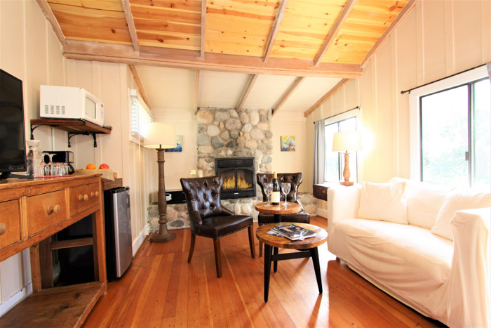 carmel lodging - room with couch, stone fireplace and TV